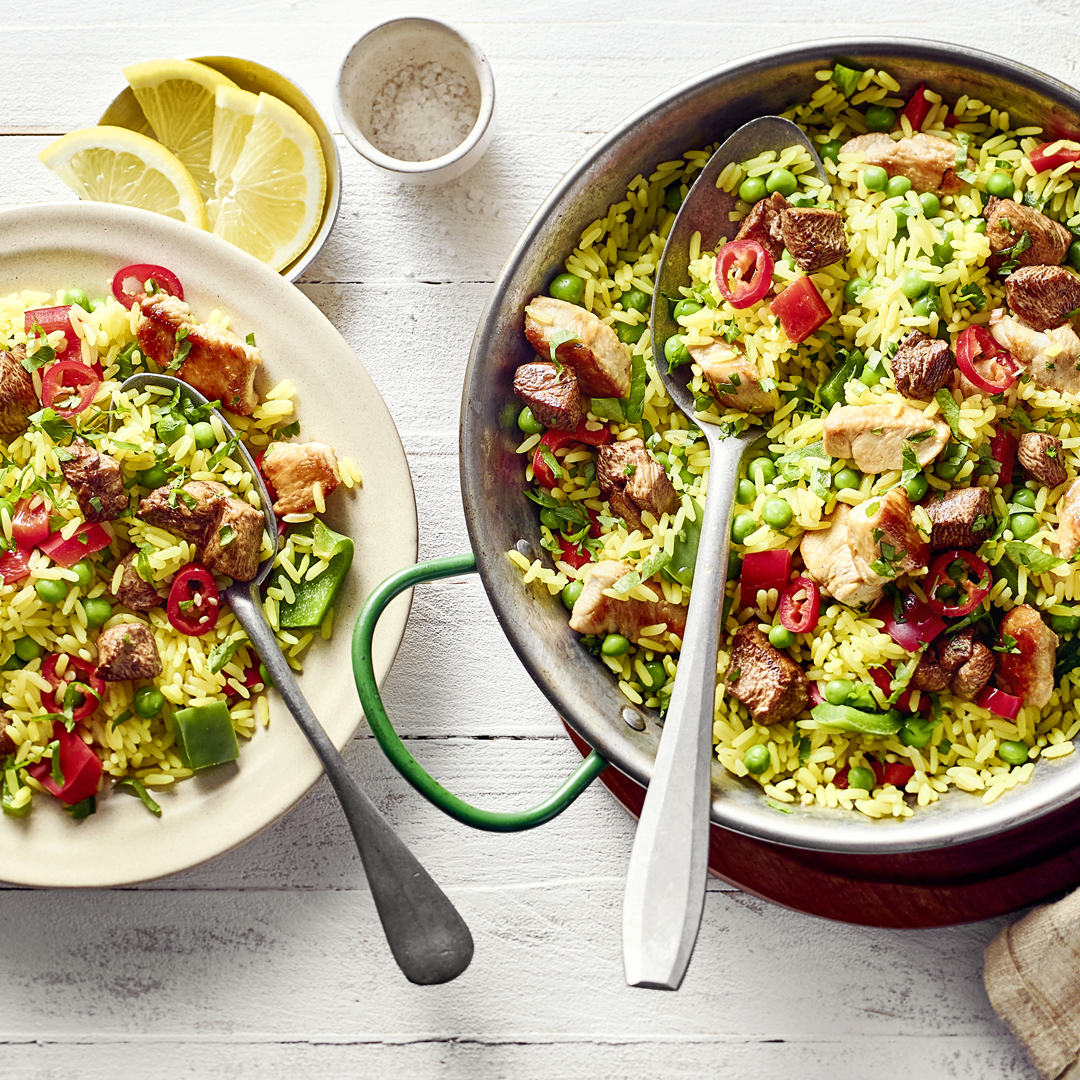 Klassische Paella mit Kaninchenrücken, Hühnerbrust, Paprika, Erbsen und Reis