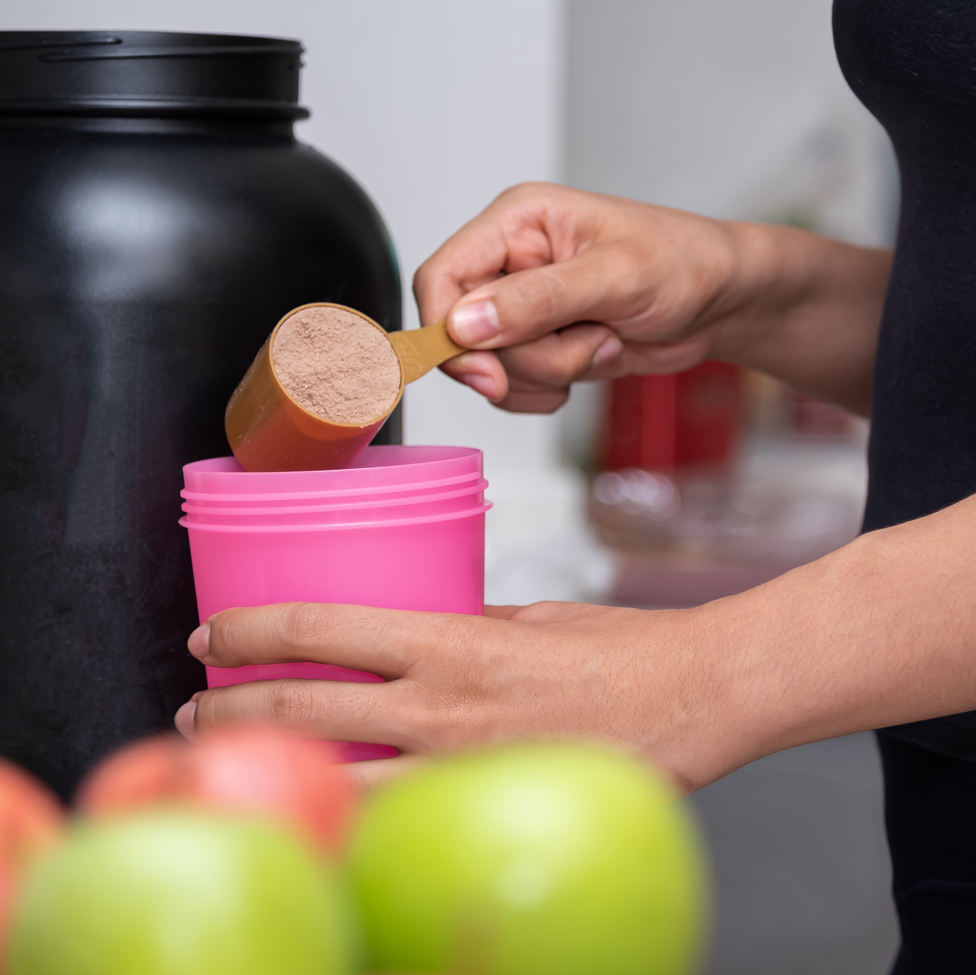 Frau bereitet Shake mit veganem Proteinpulver zu