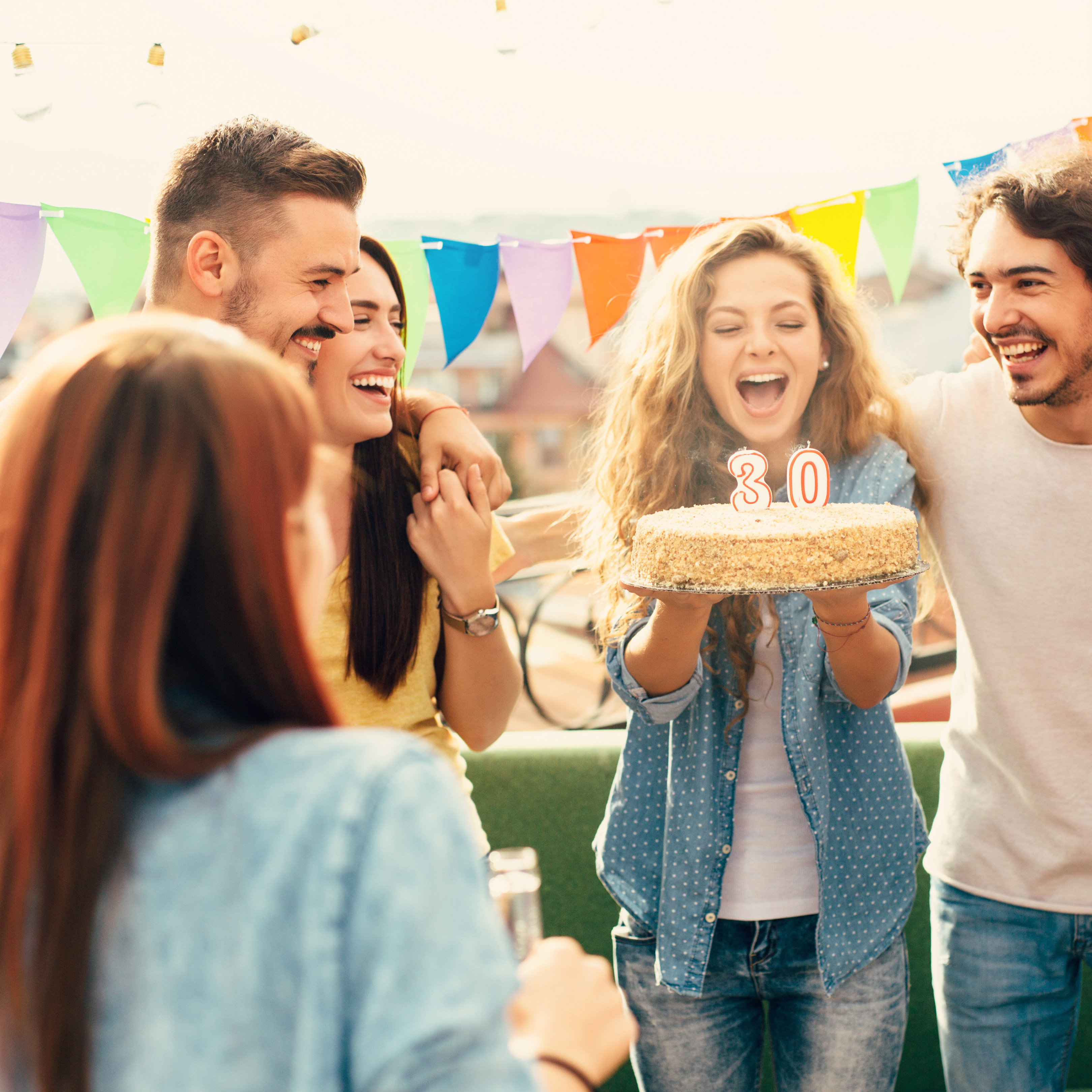 Gruppe feiert einen 30. Geburtstag draußen. 