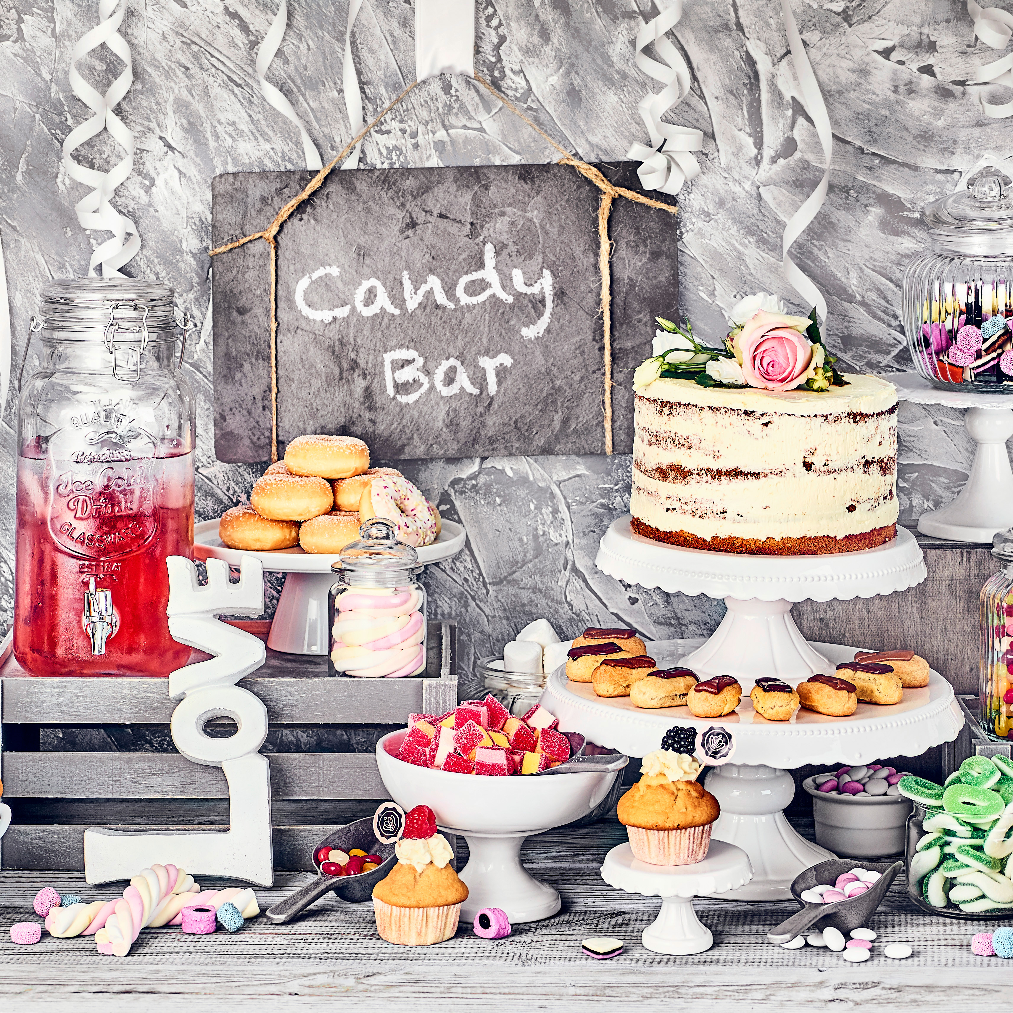 Candy Bar mit Bowle, Torte, Muffins, Donuts und zahlreichen anderen Süßigkeiten.